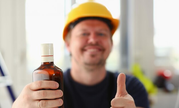 Arm of drunken worker in yellow helmet