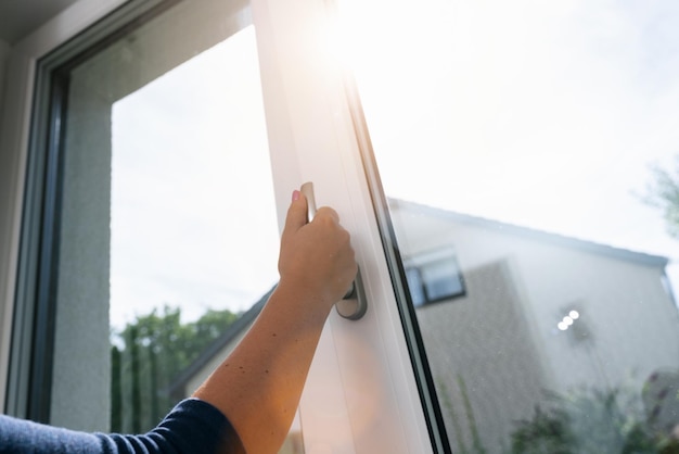 Photo arm open white plastic window with sunlight