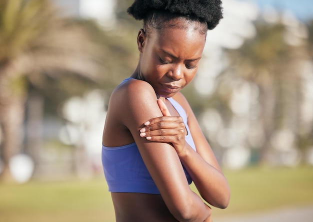 Arm pain and black woman in outdoor with injury from sport with strain from training accident Cardio muscle and shoulder inflammation with female athlete after exercise at park for workout