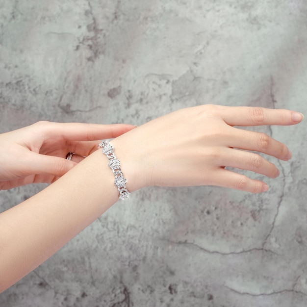 armband ingelegd met een diamant bij de hand geïsoleerd op een grijze achtergrond