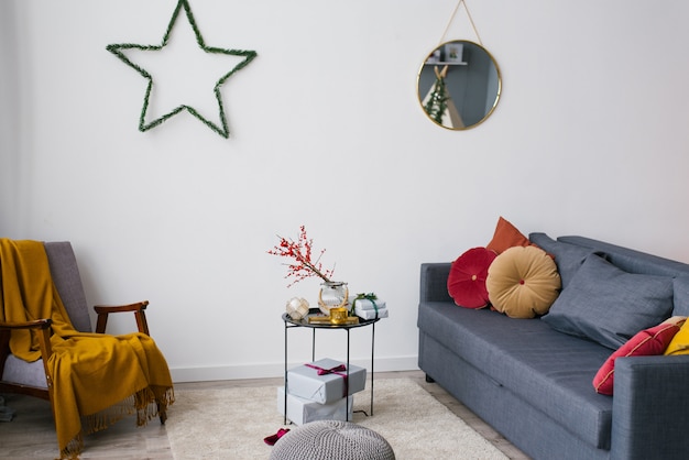 Armchair, sofa and coffee table in the living room, decorated for Christmas and New year