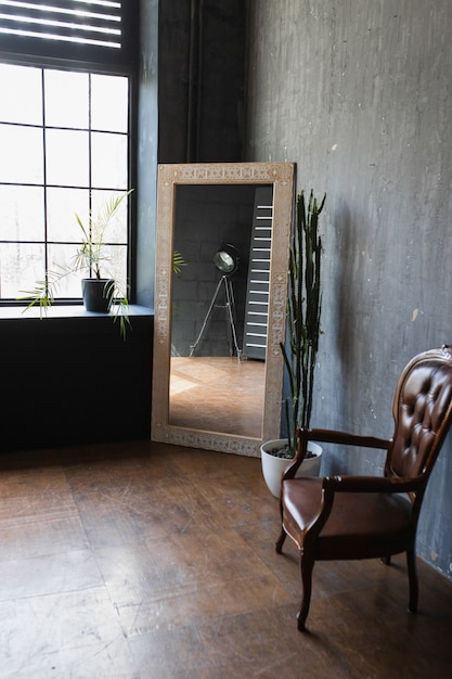 Кресло с винтажным зеркалом в интерьере в стиле лофт
