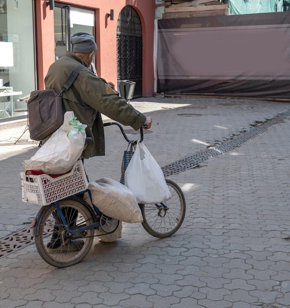 Foto arme man met een oude fiets op straat