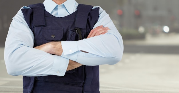 Armen van het middengedeelte van de bewaker gevouwen tegen wazige straat