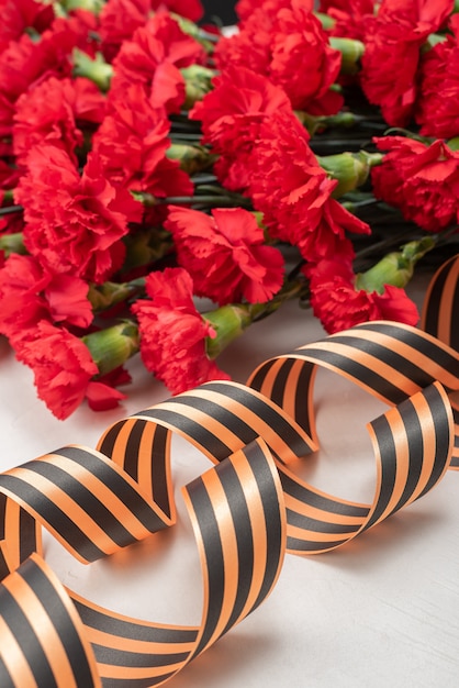 Armful carnations on dark background with ribbon