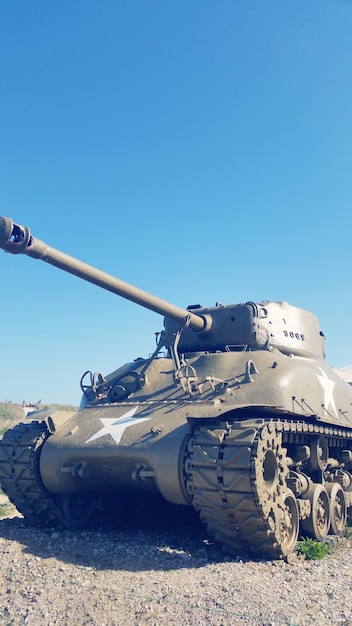Бронированный танк на поле на чистом голубом небе