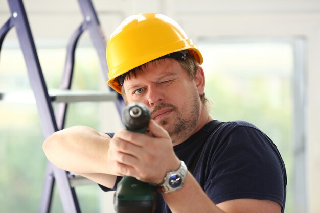 Arms of worker using electric drill closeup. Manual job DIY inspiration improvement fix shop yellow helmet joinery startup idea industrial education profession career concept