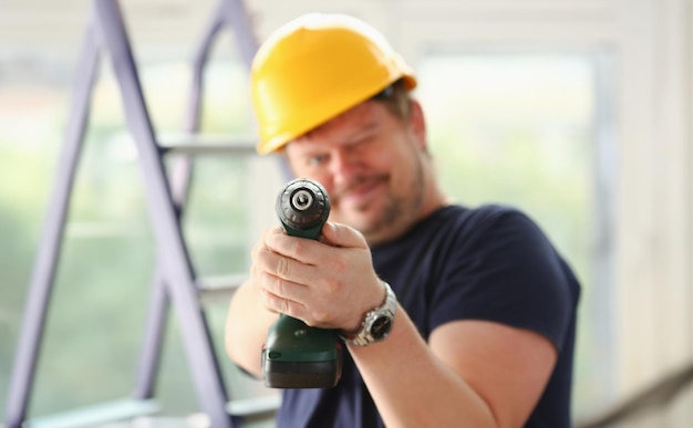 Arms of worker using electric drill closeup