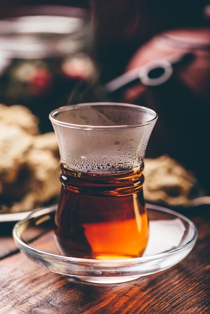 Armudu glass with black tea with kitchenware on background