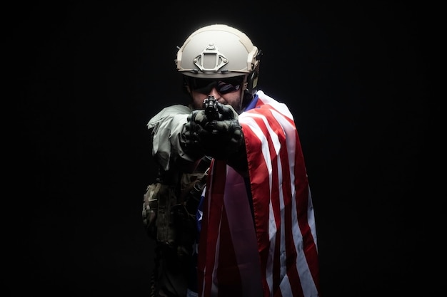 Photo army of america a soldier in military equipment with a gun holds the usa flag