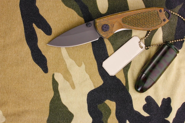 Фото Армейские значки и нож на камуфляжном фоне