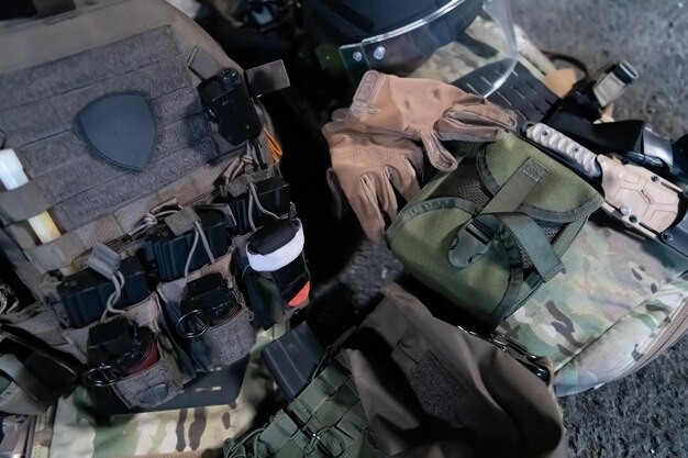 Foto casco corazzato dell'esercito e munizioni fucile d'assalto kalashnikov con matrone e tourniquet di primo soccorso composizione su legno marrone corazzato dell'esercito concetto militare a posa piatta.