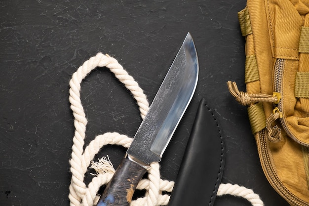 Army knife on a marching backpack background