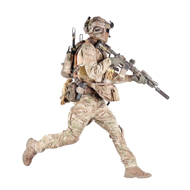 Army soldier, equipped infantryman, airsoft player in camouflage battle uniform, helmet and tactical radio headset jumping, running with assault rifle in hand studio shoot isolated on white background