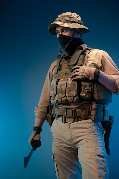 An army soldier in military clothes with a machete in his\
hand