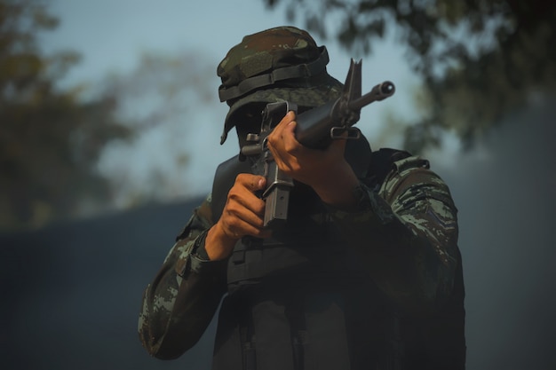 Army soldier in protective uniform holding rifle. special forces soldier assault rifle with silencer.