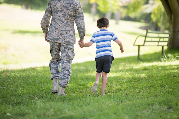 公園で少年と歩いている陸軍の兵士