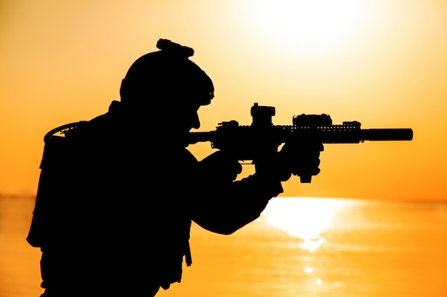 Army soldier with rifle orange sunset silhouette