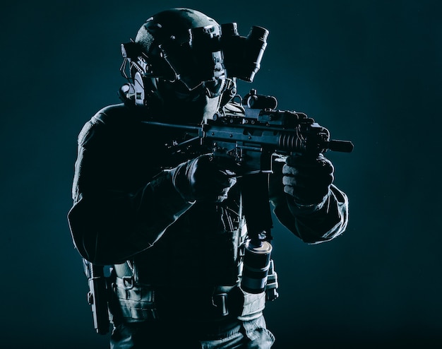 Army special operations squad soldier, police counter terrorism assault team member, security service rifleman in mask, helmet with headset and night vision device, armed short barrel service rifle