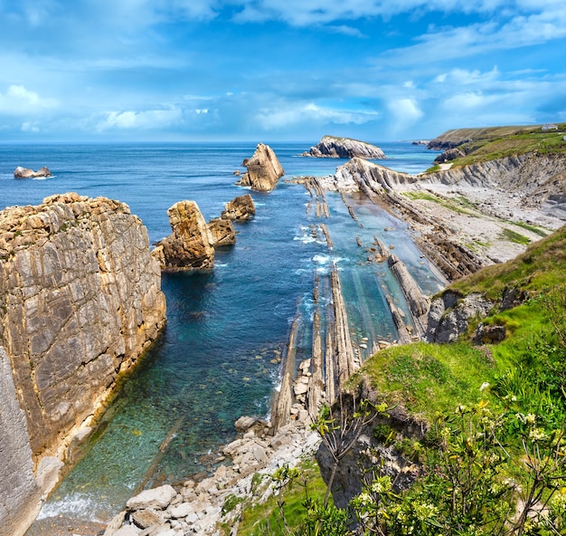 Arnia Beach (Spain). Atlantic Ocean coastline landscape with cloudy sky.