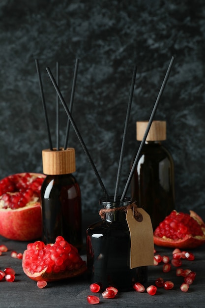Aroma geurverspreiders en granaatappel op donkere houten tafel