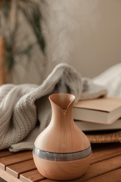 Aroma oil diffuser lamp on a blurred background in the interior of the room