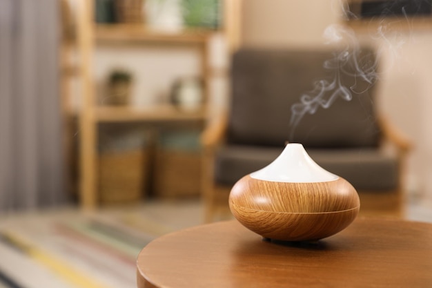 Aroma oil diffuser on wooden table at home space for text Air freshener