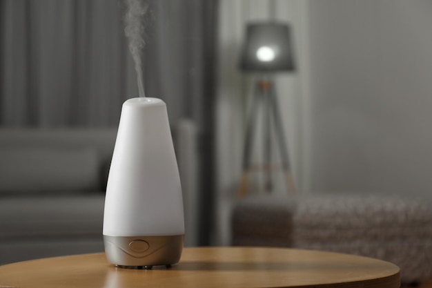 Photo aroma oil diffuser on wooden table indoors space for text air freshener