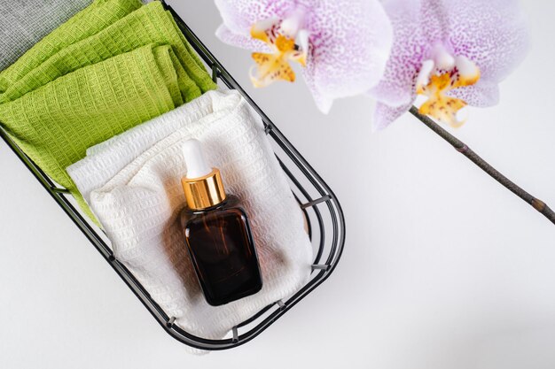 Aroma olie ligt op een handdoek in de badkamer Paarse orchideeën Eco cosmetica