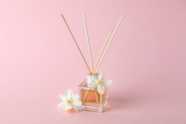 Aroma scent diffuser and flowers on pink background