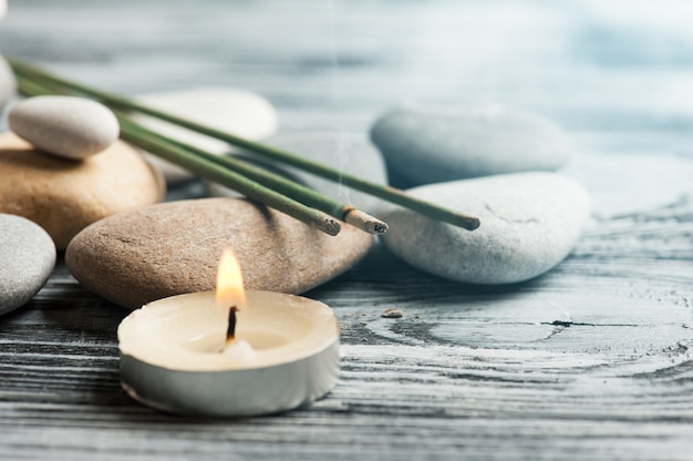 Aroma sticks, pebbles and lit candle