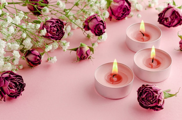 Aromatherapie concept. Drie brandende kaarsen en droge rozen