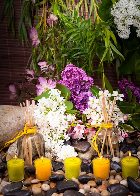 Aromatherapie, spa, schoonheidsbehandeling en wellness met massagesteen, bloemen, brandende kaarsen