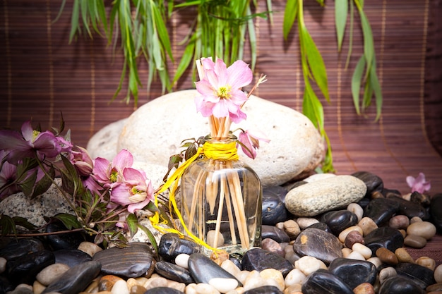 Aromatherapie, spa, schoonheidsbehandeling en wellness met massagesteen, bloemen, flacon