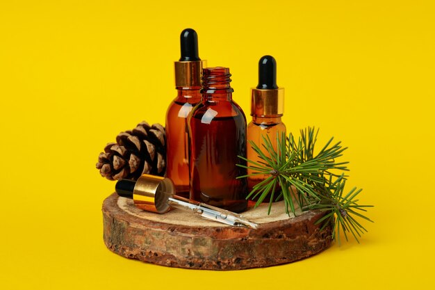 Aromatherapy concept with pine oil on yellow