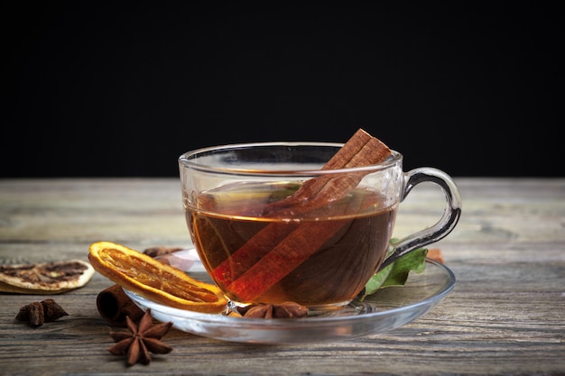 Tè alla cannella caldo aromatico sul tavolo di legno