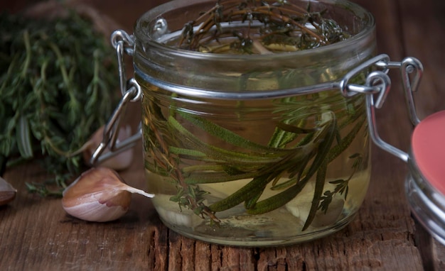 Aromatic oil of rosemary thyme and garlic in a glass jar