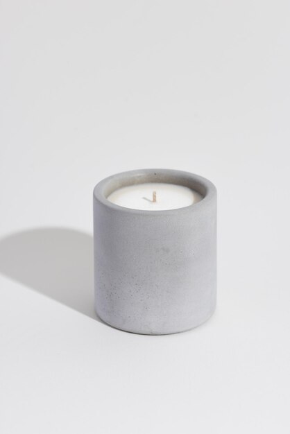 Aromatic premium soy candle in gray concrete jar isoleted on white background Photo for candle shop