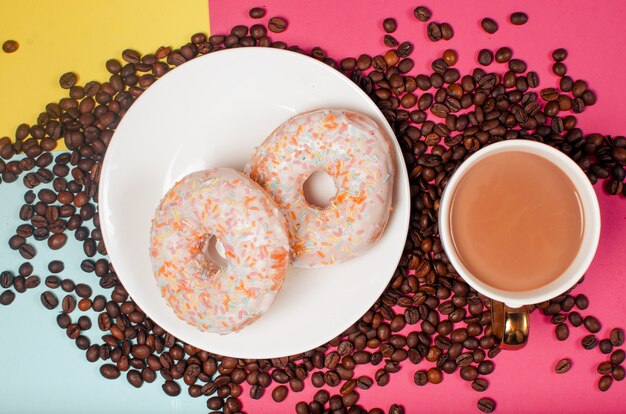 Aromatic roasted black coffee grains and fresh donuts