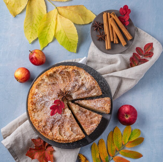 Aromatische eigengemaakte appeltaart met rode appel en kaneel op de houten blauwe lijstherfst