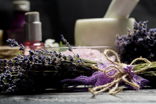 Aromatische samenstelling van lavendel, kruiden, cosmetica en zout op een donker tafelblad Premium Foto