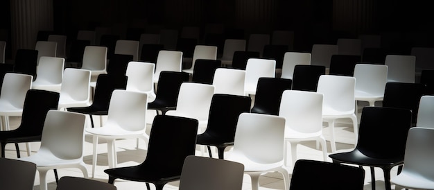 Arrangement of black chairs among white ones