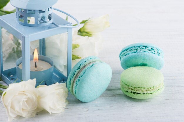 Photo arrangement of blue lanter, flowers, macaroons