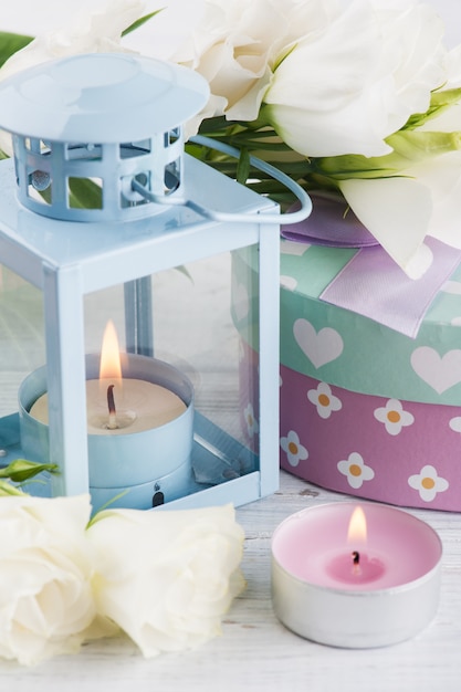 Arrangement of blue lanter, flowers, pastel gift box