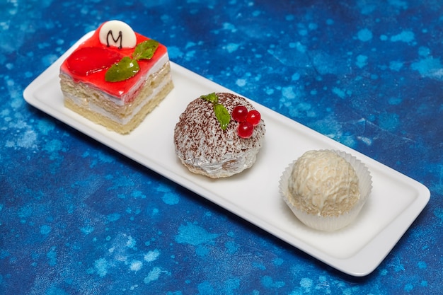 Arrangement of cake and candies on long white plate