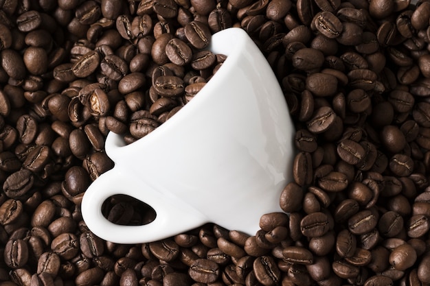 Photo arrangement of  roasted coffee beans and white cup