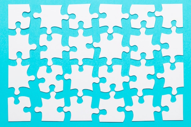 Foto disposizione del pezzo di puzzle bianco su sfondo blu