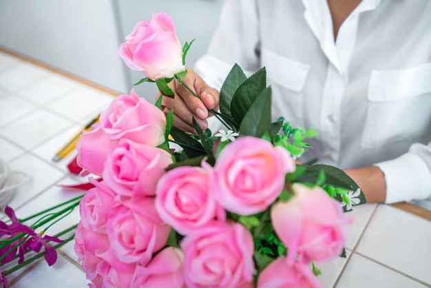 Foto organizzare la decorazione di fiori artificiali a casa giovane donna fiorista lavoro facendo organizzare fiori artificiali fai da te artigianato e concetto fatto a mano