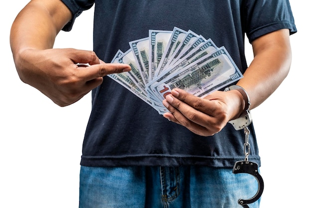 Arrested man with a handcuff on his hand holding money isolated over a white background