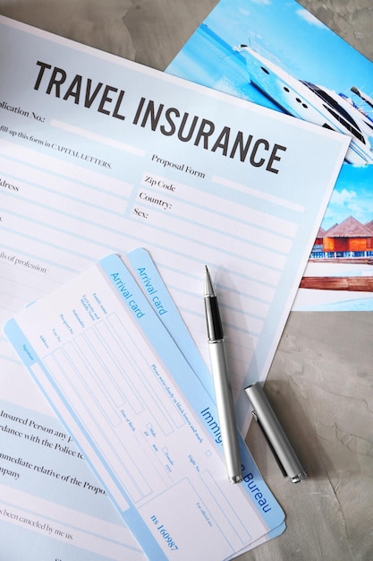 Arrival cards and pen on blank travel insurance form closeup